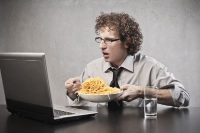 man-eating-spaghetti-whilst-using-his-computer